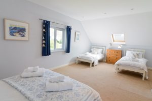 First floor King sized bedroom with additional twin beds at Little Tremawr