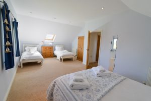 First floor King sized bedroom with additional twin beds adjacent, at Little Tremawr