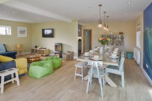 Dining and lounge area with mounted TV and log burner at Rumah Panjang