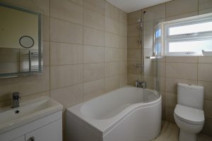 Ground floor bathroom with bath tub and overhead shower at Rumah Panjang