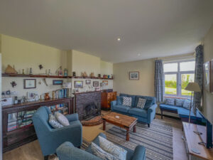 Lounge at 't Sandt with seating in front of fireplace with ornaments and books in display unit