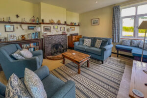 Lounge at 't Sandt with seating in front of fireplace with ornaments and books in display unit