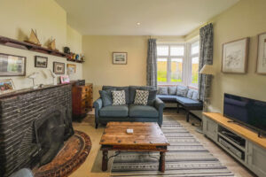 Lounge at 't Sandt with TV, fireplace, seating and corner window with seating