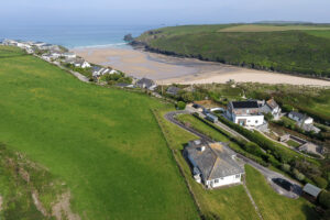 Aerial drone shot over Porthcothan Bay with 't Sandt in the foreground