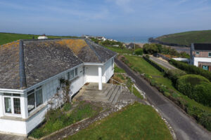 Aerial view of the front of 't Sandt showing driveway, with steps and handrail up the the front door and view out to the ocean over other properties