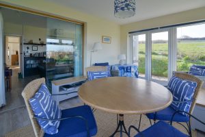 Sun room at 't Sandt with table and chairs and sliding glass doors into the lounge