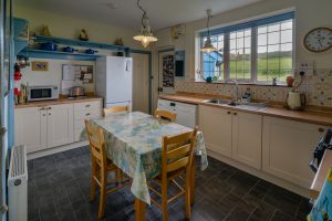 Kitchen at 't Sandt with table and chairs, and other facilities.