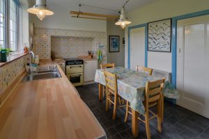 Kitchen at 't Sandt showing table and chairs, cooker and kitchen sink