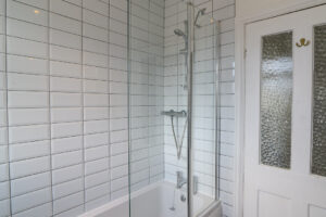 Ground floor bathroom with bath and overhead shower at Lowena