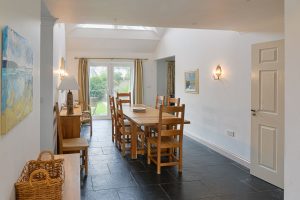 Dining area with double doors leading to the garden at Bass Cottage