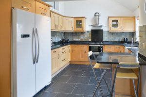 Kitchen area at Bass Cottage with large fridge/freezer, gas hob and integrated oven