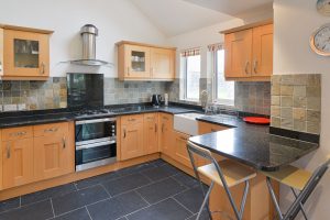 Well equipped kitchen at Bass Cottage with bar stools