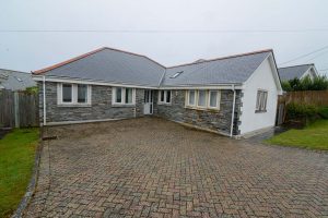 Front exterior view of Bass Cottage with parking