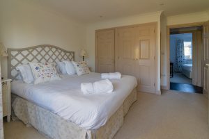 Master bedroom with storage and door leading to hallway at Bass Cottage