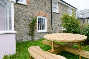 Outside area with wooden picnic table at Treburrick Farm House