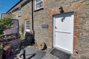 Picture of the exterior of the stable door to the kitchen and name plate on wall at Treburrick Farm House