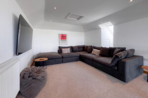 The third floor living room at Tristan with ample seating and wall mounted tv