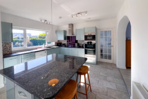 The kitchen and breakfast room at Tristan with large kitchen island and window to the rear garden and archway into the dining room