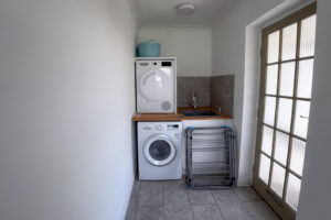 The utility room at Tristan is off the kitchen breakfast room with sink, washing machine and tumble dryer.