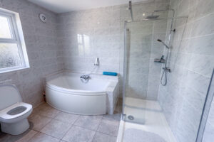 The family bathroom at Tristan which is off the first floor hallway and has a bath, shower cubicle and toilet and wash basin