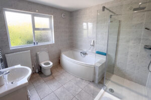The family bathroom at Tristan which is off the first floor hallway and has a bath, shower cubicle and toilet and wash basin