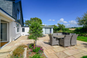 Large patio to the rear of San Marcos with shrubs and table and chairs