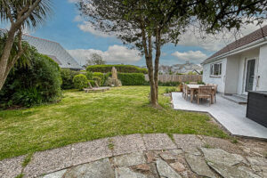 The rear garden with grassed lawn and patio at Tristan