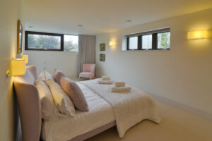 The master ensuite king bedroom on the lower ground floor at Spin with high level windows to two sides of the room