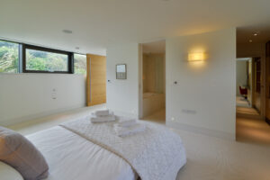 The second king bedroom on the lower ground floor at Spin with doors into the ensuite and dressing area. This room has high level window to one side