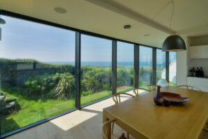Large windows with views over the ocean from the open plan kitchen dining area at Spin