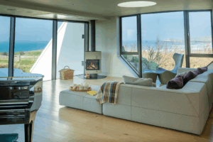 Large windows with views from the lounge area at Spin with woodburner in the corner