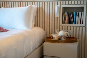 One of the twin beds with bedside table and books in the ground floor twin bedroom at Spin