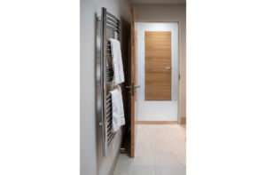 Heated towel rail and door door into the shower room next to the twin bedroom on the ground floor