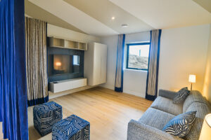 The sofa bed in the area off the games room on the ground floor at Spin with window to the side and wall mounted tv.