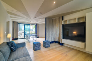 The large wall mounted tv in the sofa and games room at Spin with glass doors leading into the courtyard