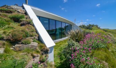 Exterior picture of the large window to the side of Spin with views out towards the ocean from the living room and the open plan kitchen and dining area