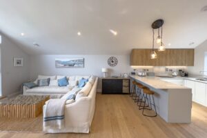 Open plan lounge and kitchen area with bar stool seating at No 1 Treglos Gardens