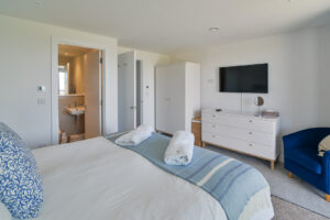 Ground floor ensuite superking bedroom with bedroom furniture and TV at Quiescence