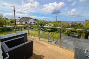 Decking area with steps leading to patio and grassed garden at Coronado