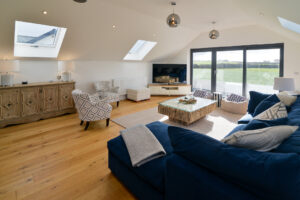 First floor sitting room with TV and ample seating, double doors to balcony at Morwynsow