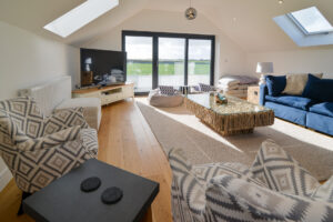 Large lounge with doors leading to a balcony at Morwynsow