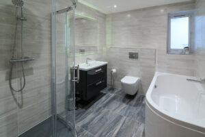 Main bathroom on the ground floor with shower cubicle and separate bath tub, toilet and wash basin at Morwynsow