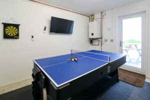Games room and garage area on the ground floor with table tennis table, wall mounted TV at Morwynsow
