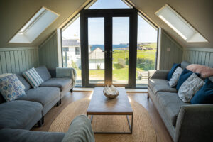 The second floor sitting room at Tremblaze with floor to ceiling window and double door onto the balcony