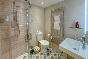 The ensuite to the ground floor twin bedroom at Tremblaze with toilet, wash basin and shower cubicle