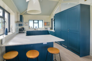 First floor kitchen at Tremblaze with breakfast bar and stools and windows to the front and side of the house