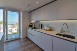 The kitchen at The View with sliding door onto the balcony and ample worktop and overhead cupboards