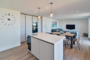 The open plan living area at The View with kitchen island, dining table and chairs and seating and tv in the lounge area