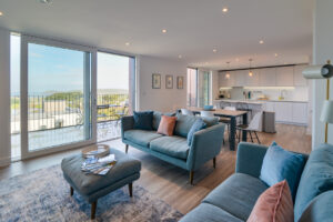 The open plan living area at The View with large sliding doors on the balcony with views to the ocean and Trevose Head