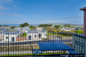 View over adjoining properties from the balcony to the ocean and Trevose Head